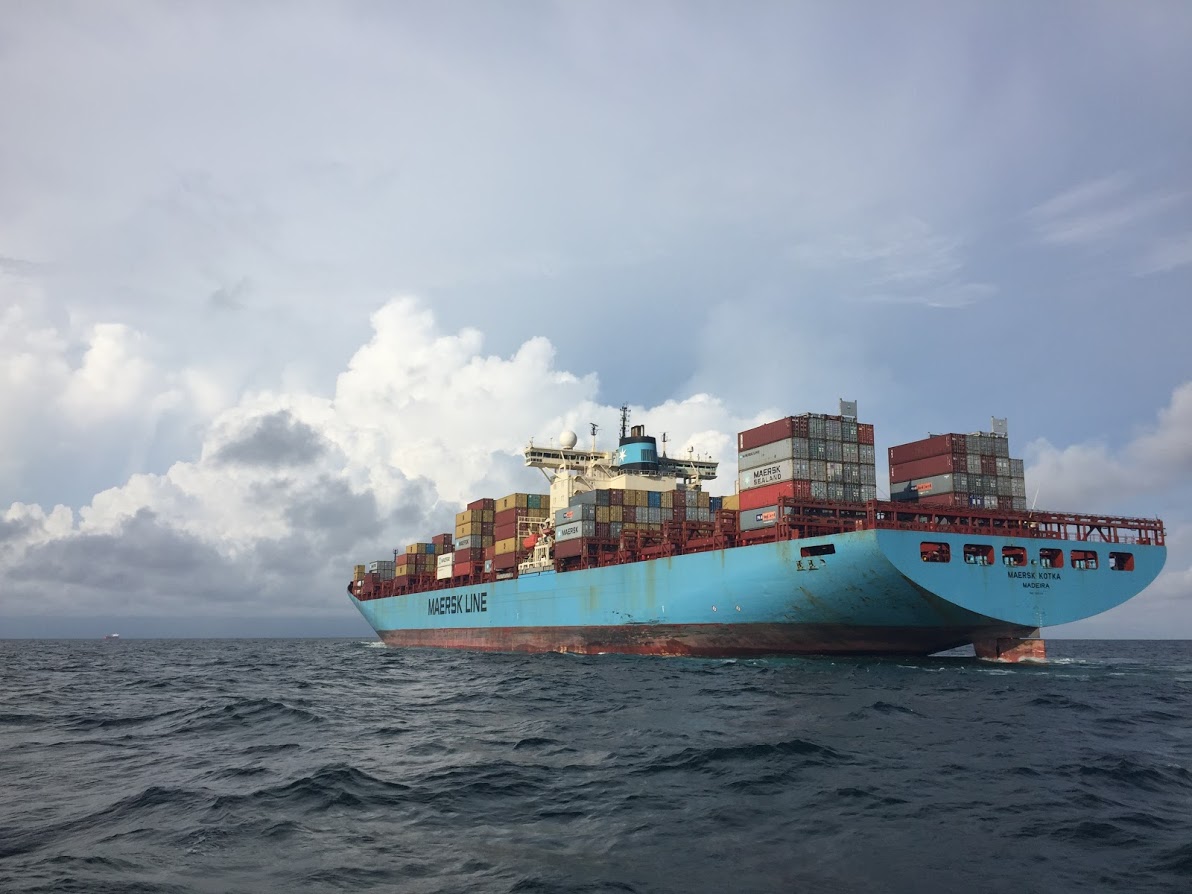 A cargo ship stacked with shipping containers on open water.